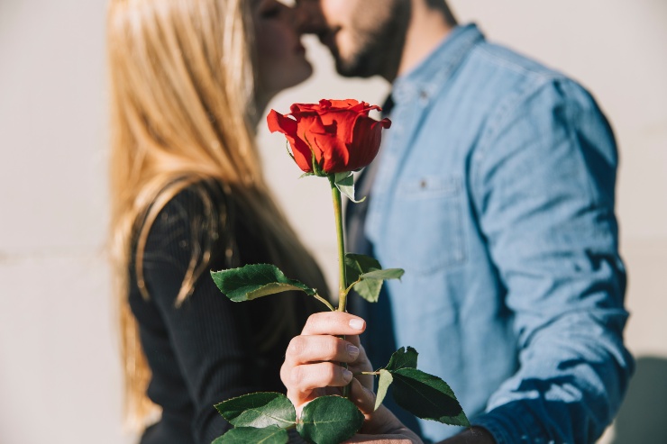 Due persone innamorate con una rosa in mano 