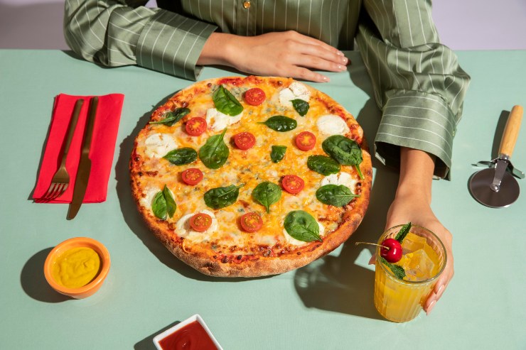 Una pizza margherita su un tavolo apparecchiato