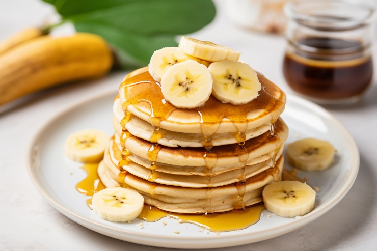 Un piatto di pancake all'avena con fettine di banana e sciroppo d'acero