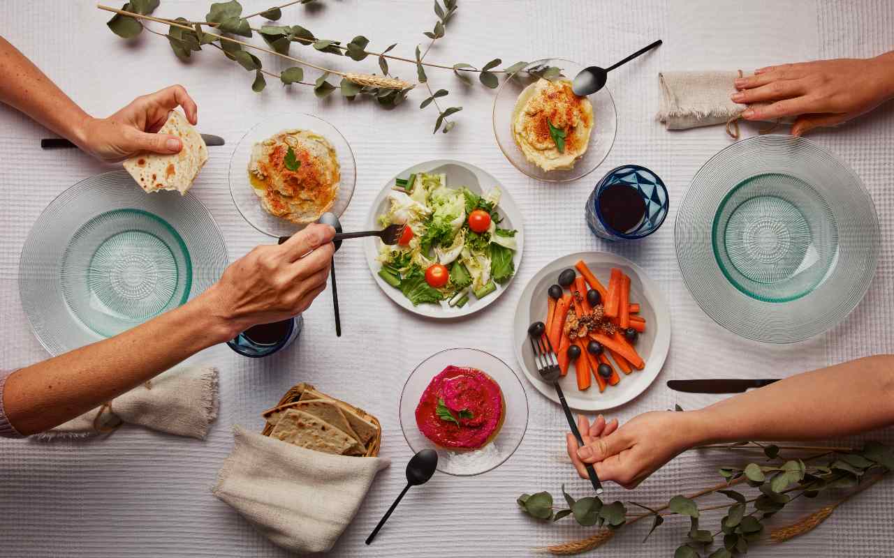 Due persone a cena che si servono da tavola